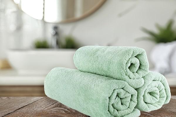 Fresh towels on wooden table in spa area of hotel