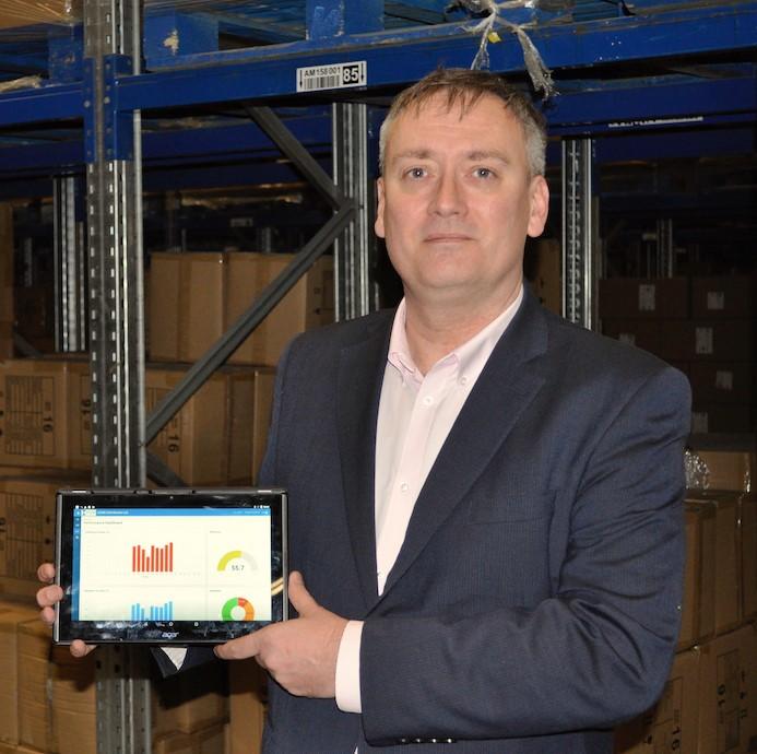 A man in a suit holding a digital tablet displaying various graphs