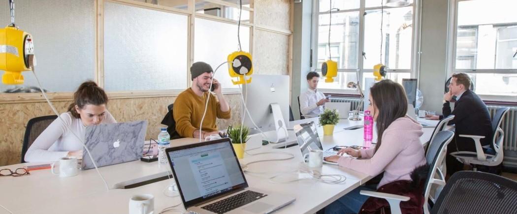 Employees of Unbxd sat at their laptops working in an office