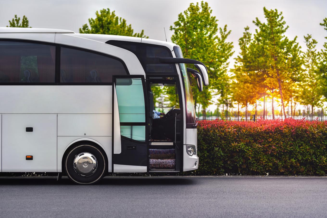 side view of a white luxury bus with the door opened