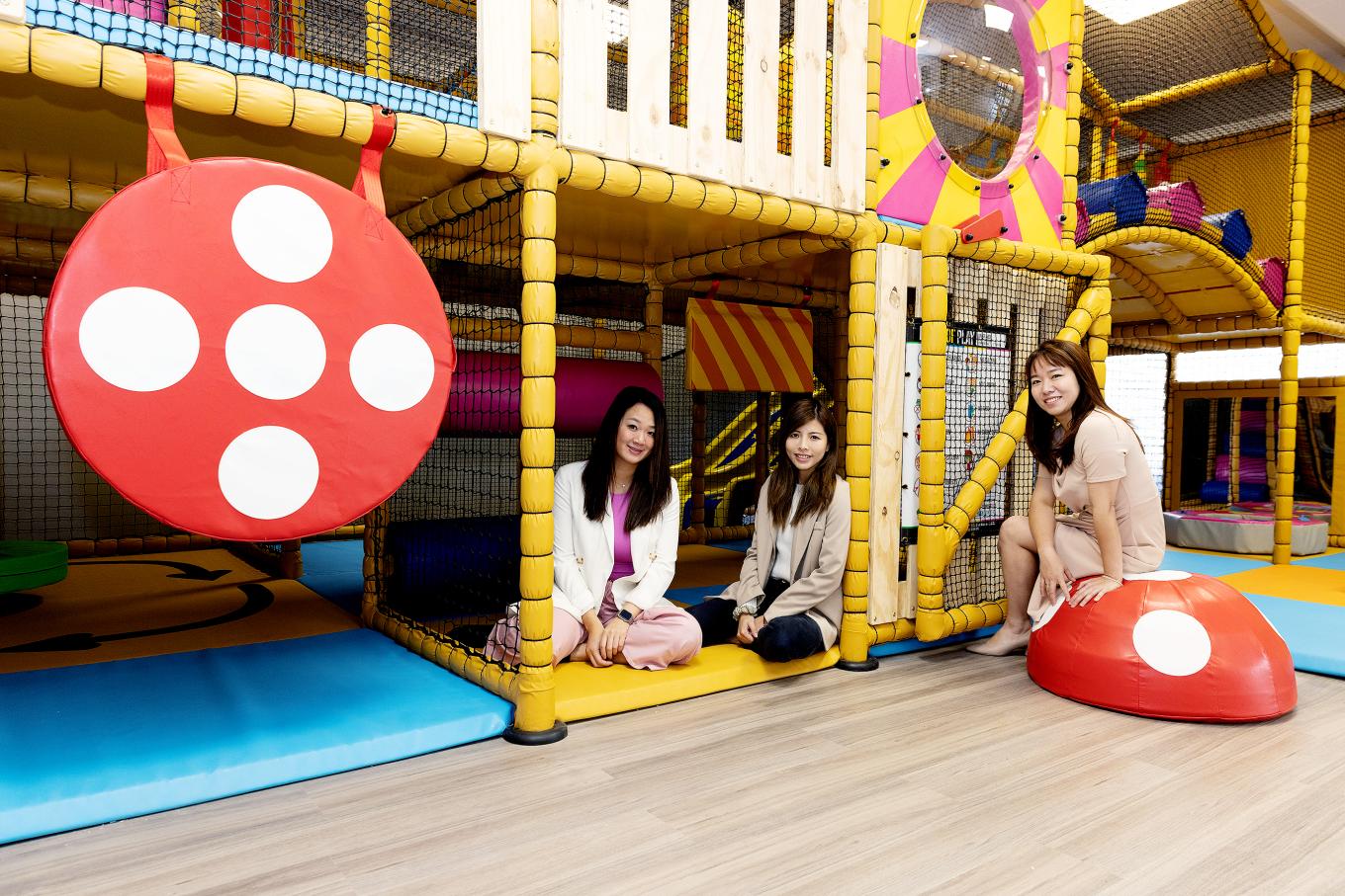 three ladies sitting in a kids soft play centre