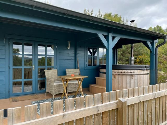 An image of a cabin with an outdoor hot tub in the Highlands of Scotland
