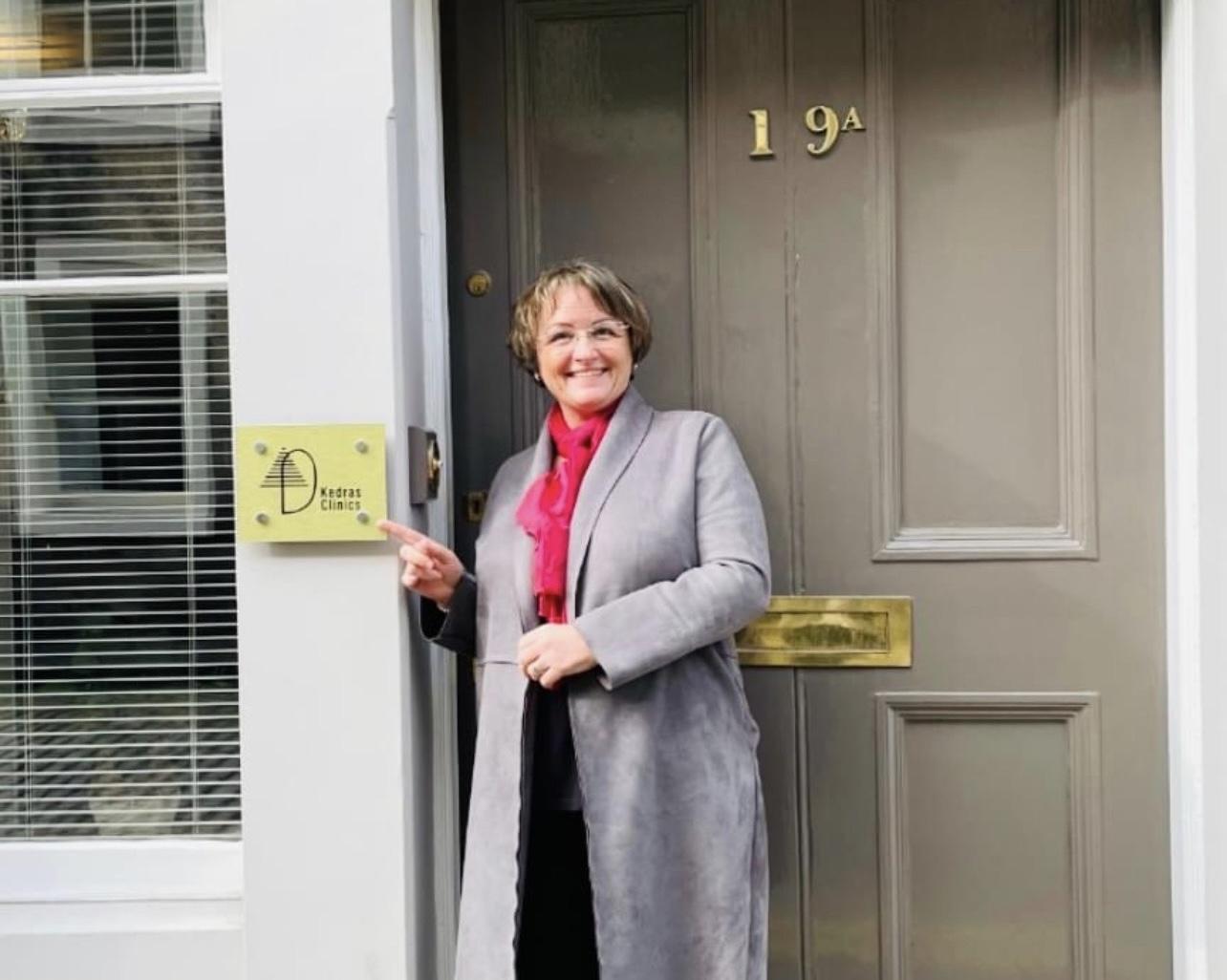 Photo of Kedras Clinics founder Dawn Harris next to her clinic front door