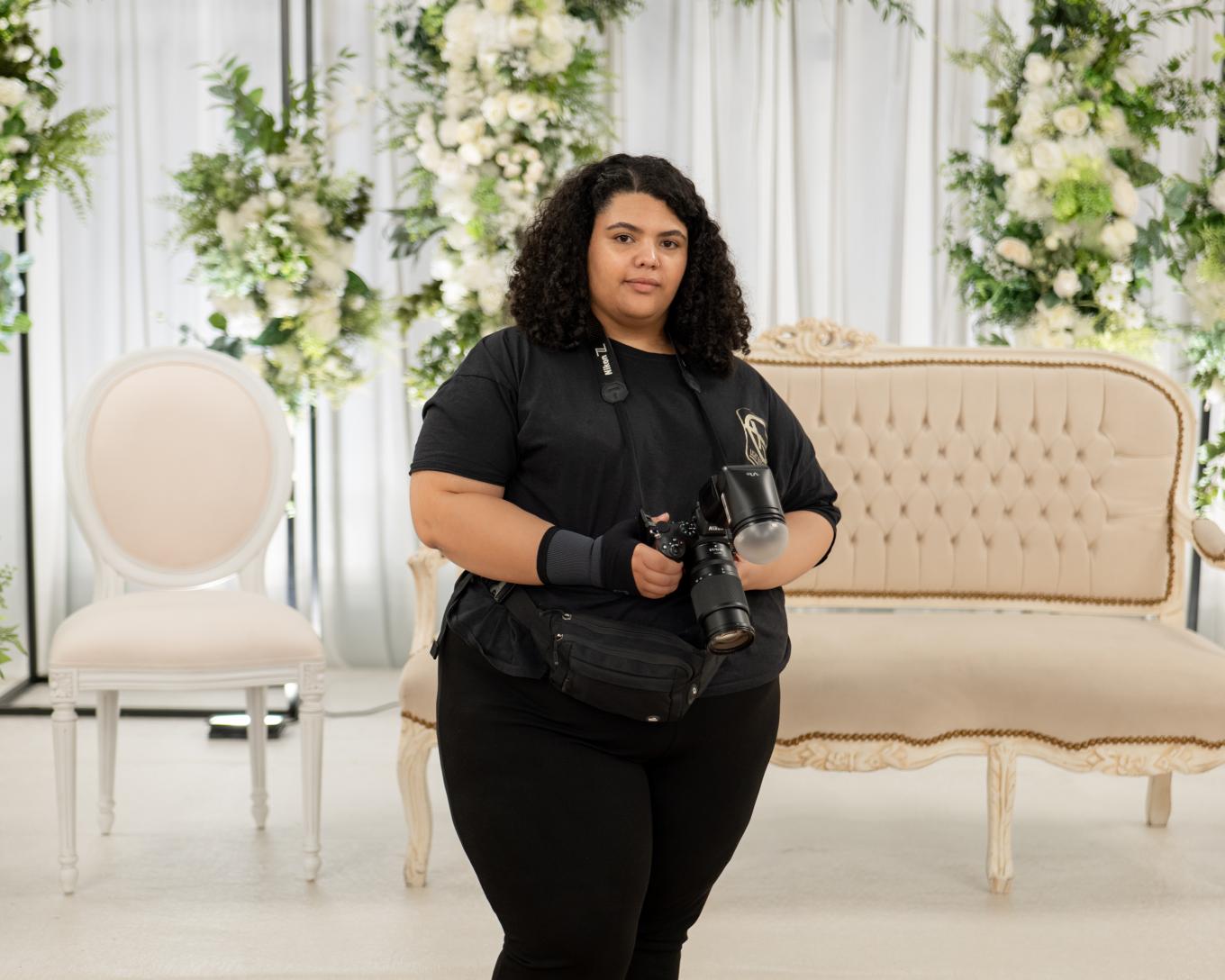 Photographer holding a camera set in a beautifully decorate venue 